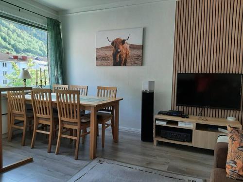 Apartment in Rjukan في Rjukan: غرفة معيشة مع طاولة وبقرة على الحائط