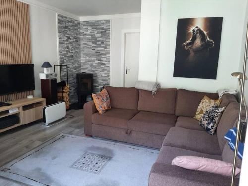 a living room with a brown couch and a tv at Apartment in Rjukan in Rjukan