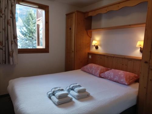 琴山朗勒堡的住宿－Résidence Les Alpages 4 étoiles - Appartement 4 personnes - Piscine, Hammam, Sauna, Jacuzzi - ValCenis 73480，一间卧室配有一张床,上面有两条毛巾