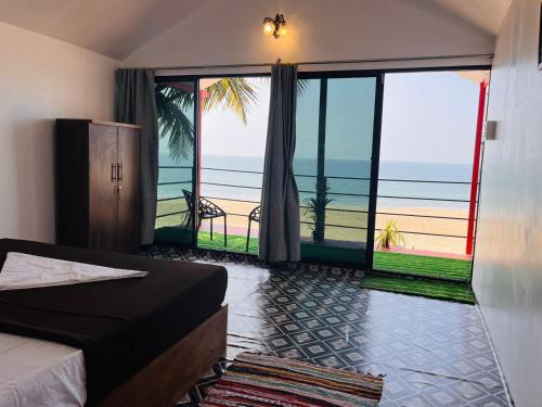 Una habitación con cama y vistas al océano. en Casa fiesta Sea front beach huts, en Patnem