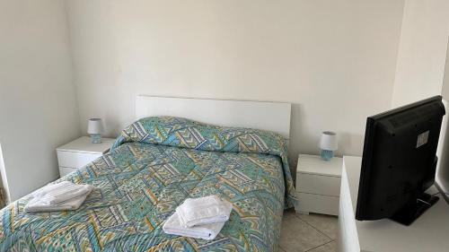 ein Schlafzimmer mit einem Bett und einem TV in der Unterkunft Il villino in Santa Marinella