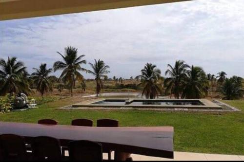 a view of a park with palm trees and a pool at Vista Mar Relax in Mañanitas