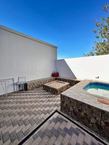a patio with a swimming pool and a building at The Olive Branch Guesthouse and Animal Sanctuary in Upington