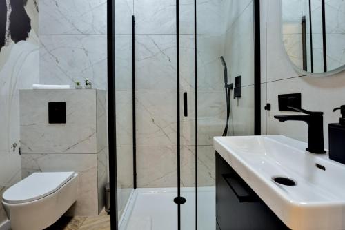 a bathroom with a toilet sink and a shower at VacationClub - Old Town Apartament 9 in Kłodzko