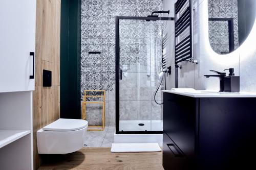 a bathroom with a shower and a toilet and a sink at VacationClub - Old Town Apartament 5 in Kłodzko