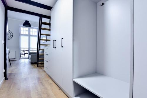 a hallway with white cabinets and a staircase in a house at VacationClub - Old Town Apartament 2 in Kłodzko