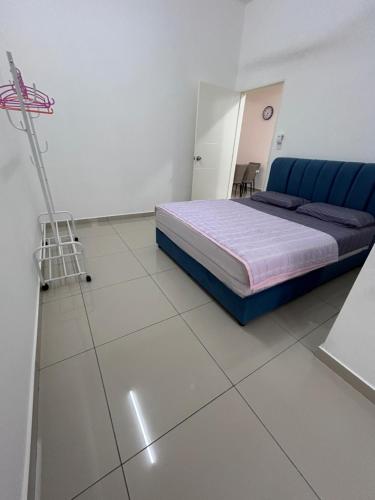 a bedroom with a bed and a white tiled floor at Cool Gateaway Seremban Homestay in Labu