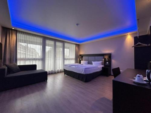 a hotel room with a bed and a couch and a room at Zi Hotel in Karlsruhe