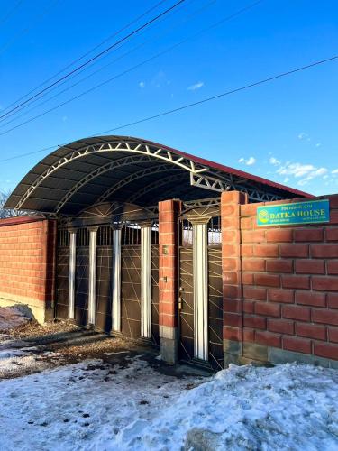 a brick building with an archway on top of it at Datka Guesthouse in Karakol