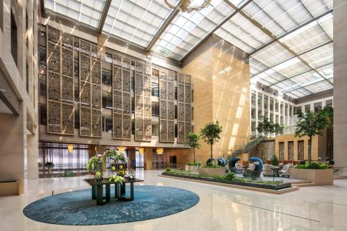 eine Lobby eines Gebäudes mit einer großen Glasdecke in der Unterkunft Intercontinental Jinan City Center, an IHG Hotel in Jinan