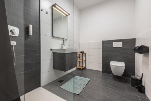 a bathroom with a toilet and a sink at myQuartier Central City Suites in Innsbruck