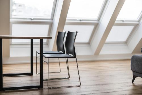 two chairs sitting at a table in a room with windows at myQuartier Central City Suites in Innsbruck