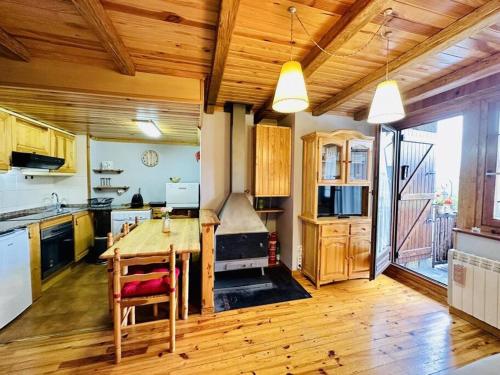 cocina con mesa de madera y techo de madera en Ca La Mimi, en Taüll