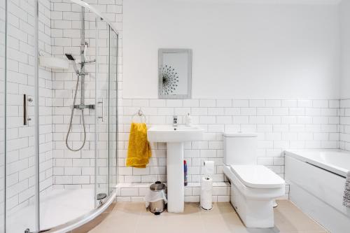 a white bathroom with a sink toilet and a shower at Comfortable and Peaceful House in St Helens in Thatto Heath