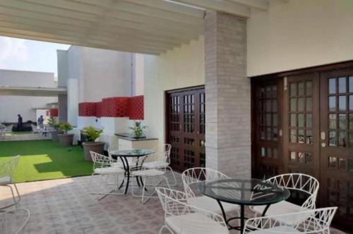 a patio with tables and chairs and a green rug at Good Stay Studio Apartment 307 in Dabolim