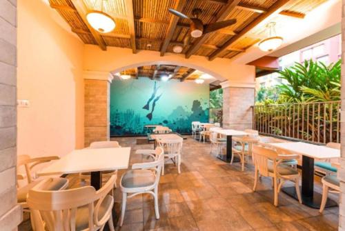 a restaurant with tables and chairs and a mural at Good Stay Studio Apartment 307 in Dabolim