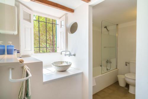 a bathroom with a sink and a toilet and a window at Son Fiol in Alcudia