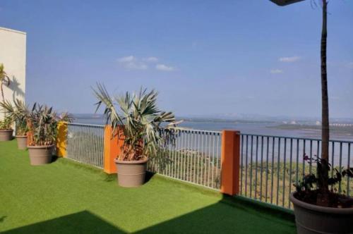 a balcony with potted plants and the ocean at Good Stay Premium Studio Apartment 206 in Dabolim