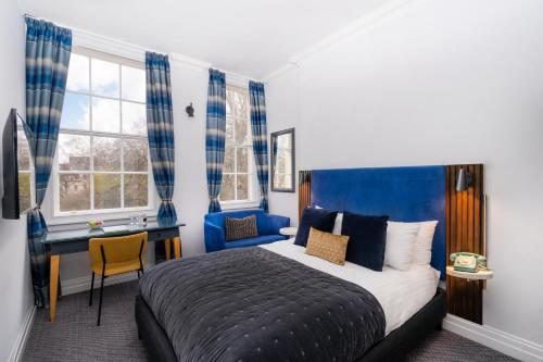 um quarto com uma cama, uma secretária e uma janela em The Berkeley Square Hotel Bristol em Bristol