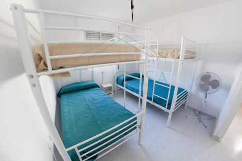 Pokój z 2 łóżkami piętrowymi i wentylatorem w obiekcie Villa Parra w mieście Chiclana de la Frontera