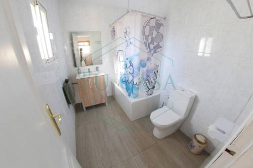 W łazience znajduje się toaleta, wanna i umywalka. w obiekcie Villa Parra w mieście Chiclana de la Frontera