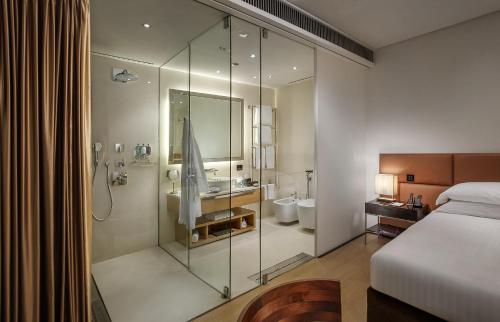 a bedroom with a shower and a bed and a bathroom at Principe Forte Dei Marmi - Resort & Spa in Forte dei Marmi