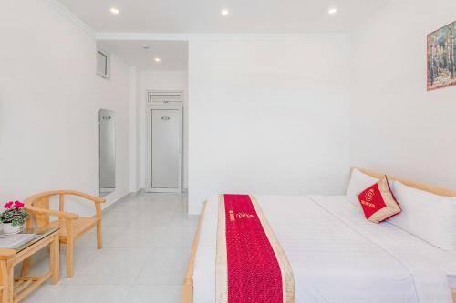 a white room with a bed and a table at Ngọc Sang 3 Hotel in Da Thanh