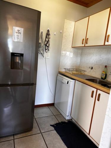 a kitchen with a stainless steel refrigerator and a dishwasher at Huisie by die See in Gansbaai