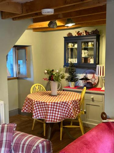 a dining room with a table and chairs and a counter at Lilac Terrace Cottage in Danby