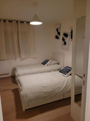 une chambre avec deux lits et un miroir dans l'établissement L'univers au blanc., à Strasbourg