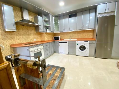 a kitchen with white cabinets and a washer and dryer at Casa Felicitas Medina in Medina del Campo