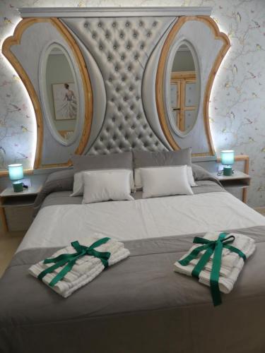 uma cama com duas toalhas com dois espelhos em Casa Felicitas Medina em Medina del Campo