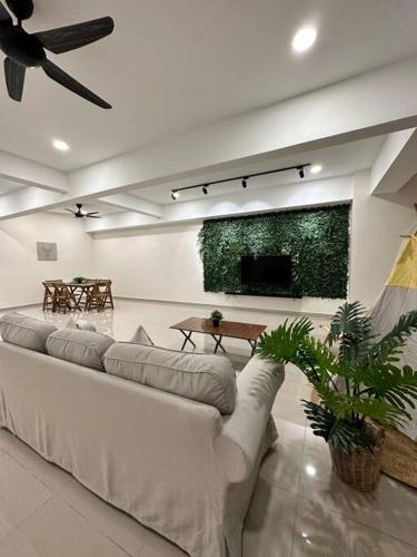 uma sala de estar com um sofá e uma televisão de ecrã plano em Grove Forest em Sitiawan