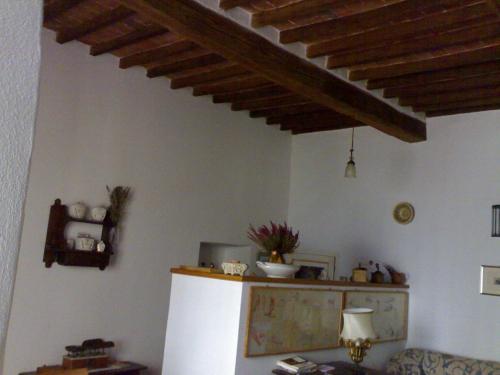 een keuken met een witte koelkast en een houten plafond bij Dormire nel Castello in Pitigliano