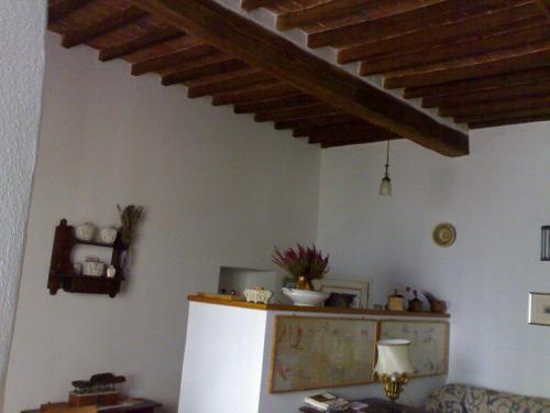 a kitchen with a white refrigerator and a wooden ceiling at Dormire nel Castello in Pitigliano