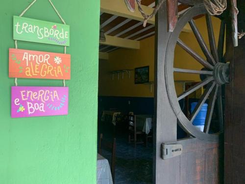 una puerta a un restaurante con carteles en la pared en Pousada dos Viajantes Posse, en Petrópolis