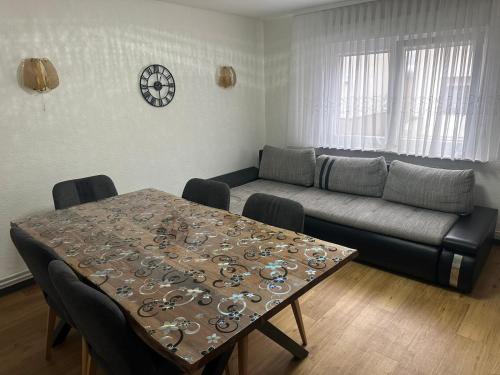 ein Wohnzimmer mit einem Tisch und einem Sofa in der Unterkunft Ferienhaus Formidable in Nidderau
