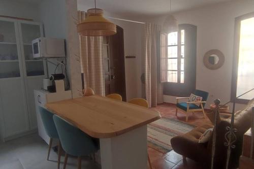 uma cozinha e sala de estar com uma mesa de madeira e cadeiras em Tu casa em Almeria