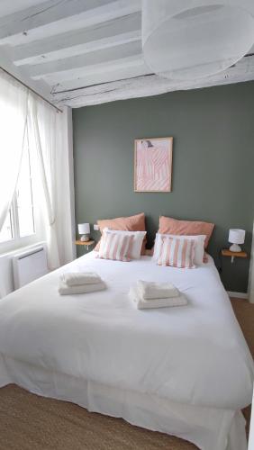 - un grand lit blanc avec 2 serviettes dans l'établissement Maison Charmeilles - La suite Pomerol, à Fronsac