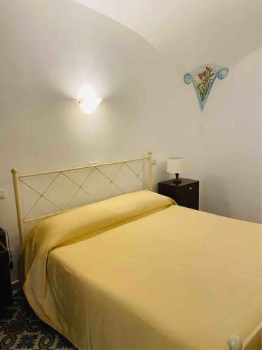 a bedroom with a bed with a yellow bedspread at Casa Cardi in Sperlonga