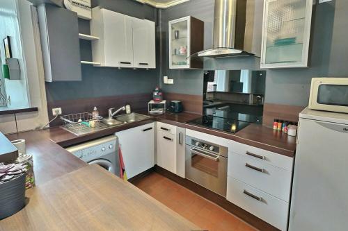 a kitchen with white cabinets and a counter top at Danton | Spacieux | WiFi | Parking | Proche Centre in Troyes