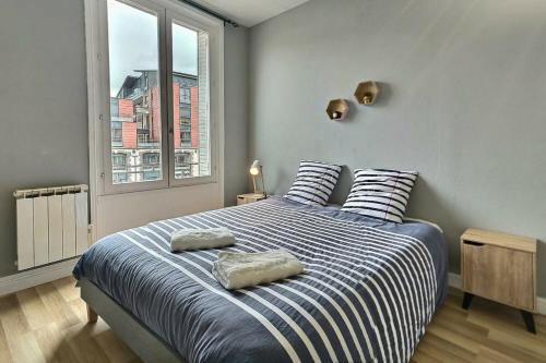 a bedroom with a bed with two pillows on it at Danton | Spacieux | WiFi | Parking | Proche Centre in Troyes
