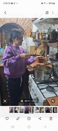 a woman standing in a kitchen preparing food at Hatzikyprianou Museum Studio in Lazania