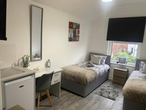 a bedroom with two beds and a desk with a desk at Abington Park 5 Bedrooms with en-suite in Spinney Hill