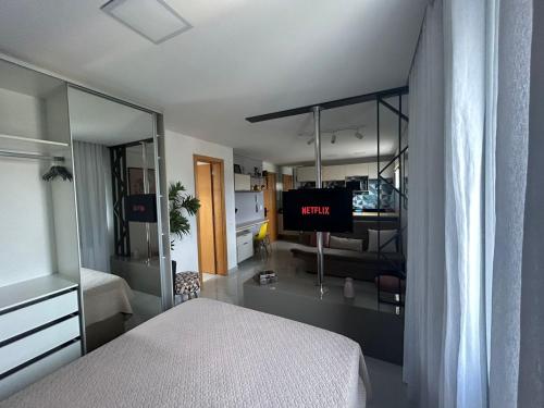 a bedroom with a bed and a tv in a room at Mi casa Su Casa Apartment Studio 1 a 4 pessoas in Curitiba