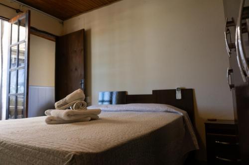 a bedroom with a bed with towels on it at Mi casa es tu casa in Melo