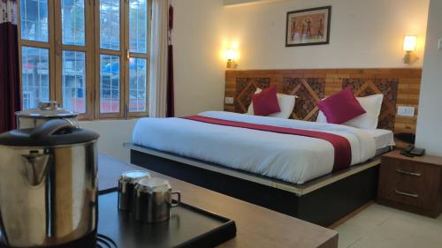 a hotel room with a large bed with red pillows at Manikarn Resort in Joshīmath