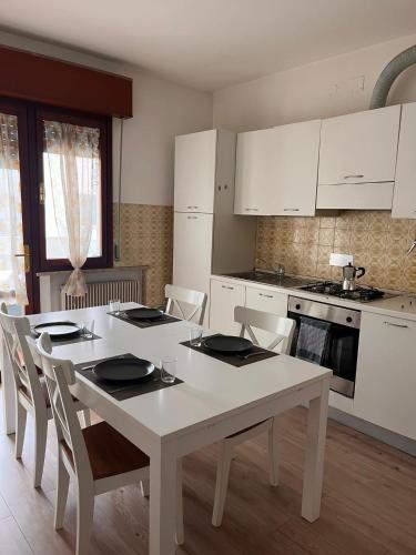 a kitchen with a white table and chairs and a stove at Casa Udine Charme 5 posti letto 