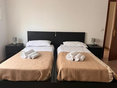 two beds with towels on them sitting next to each other at Casa Udine Charme 5 posti letto 