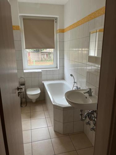 a bathroom with a tub and a toilet and a sink at Monteurswohnungen Ferropolis in Gräfenhainichen